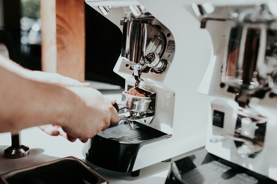Espressomühle mahlt Kaffeebohnen in einen eingespannten Siebträger